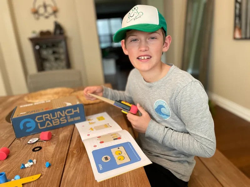 Photo of a Boy Playing with a Build Box in the Kitchen