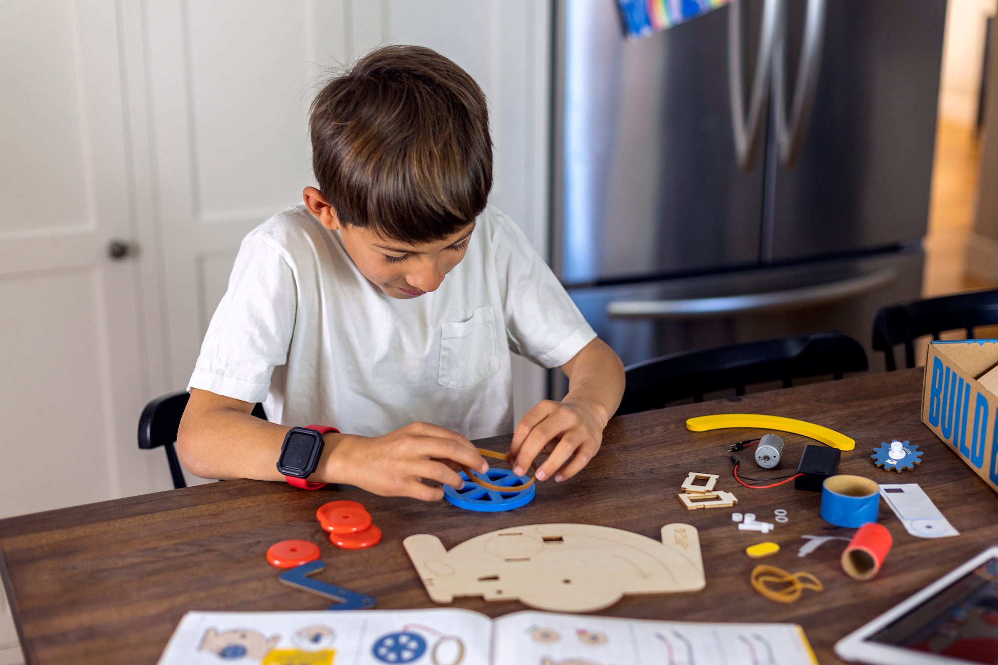 Photo of a Boy Assembling a Build Box at his Homeschool